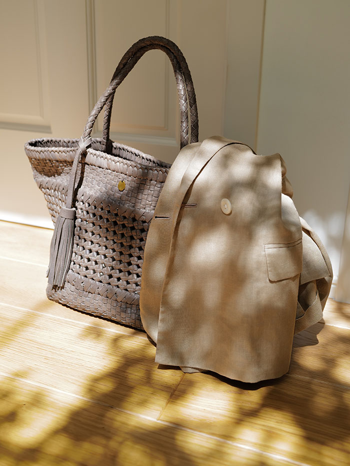 ベージュのリネンジャケットと合わせたレザーメッシュバッグのコーディネート