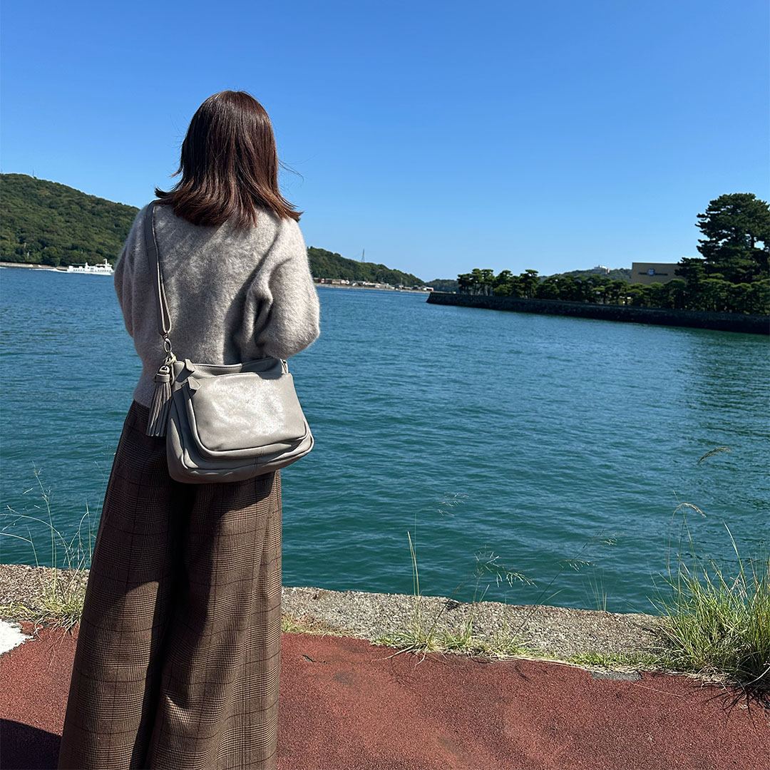 鳥羽湾を望む夫婦旅行の50代女性と旅行ショルダーバッグ