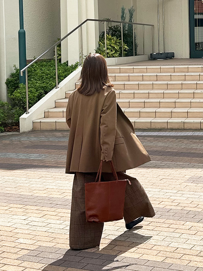 レザーバッグを持って宝塚大劇場へ向かう様子