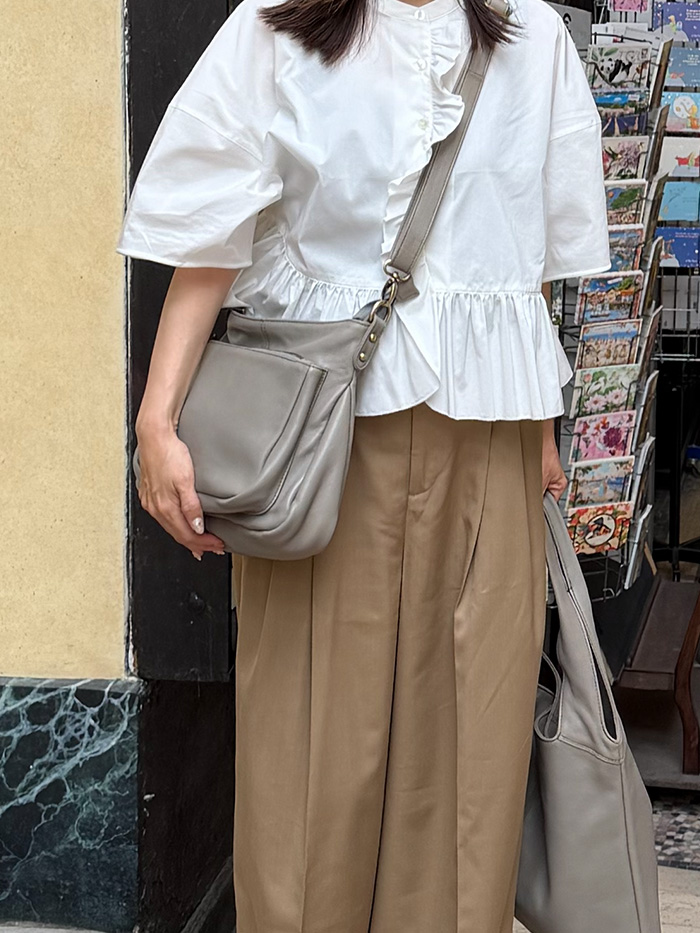 パリの街歩きでショルダーバッグを身体の前に斜めがけする50代女性