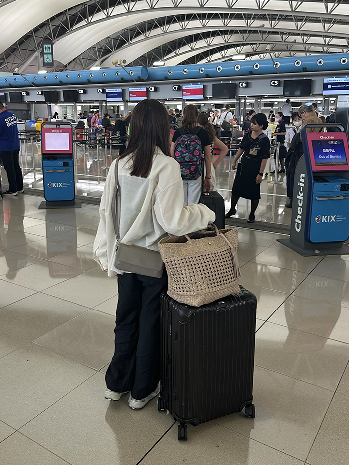 パリの街並みを本革ショルダーバッグで歩く50代女性のヨーロッパ旅行