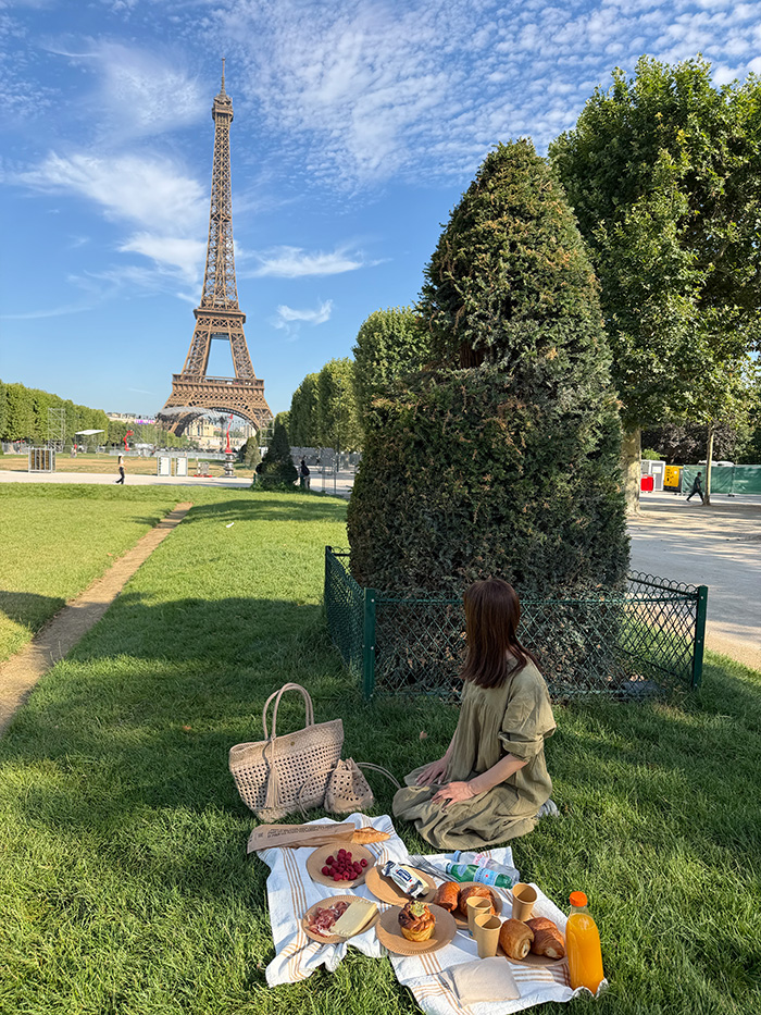 エッフェル塔を眺めながらレザーメッシュバッグとピクニックを楽しむ50代女性のパリ旅行