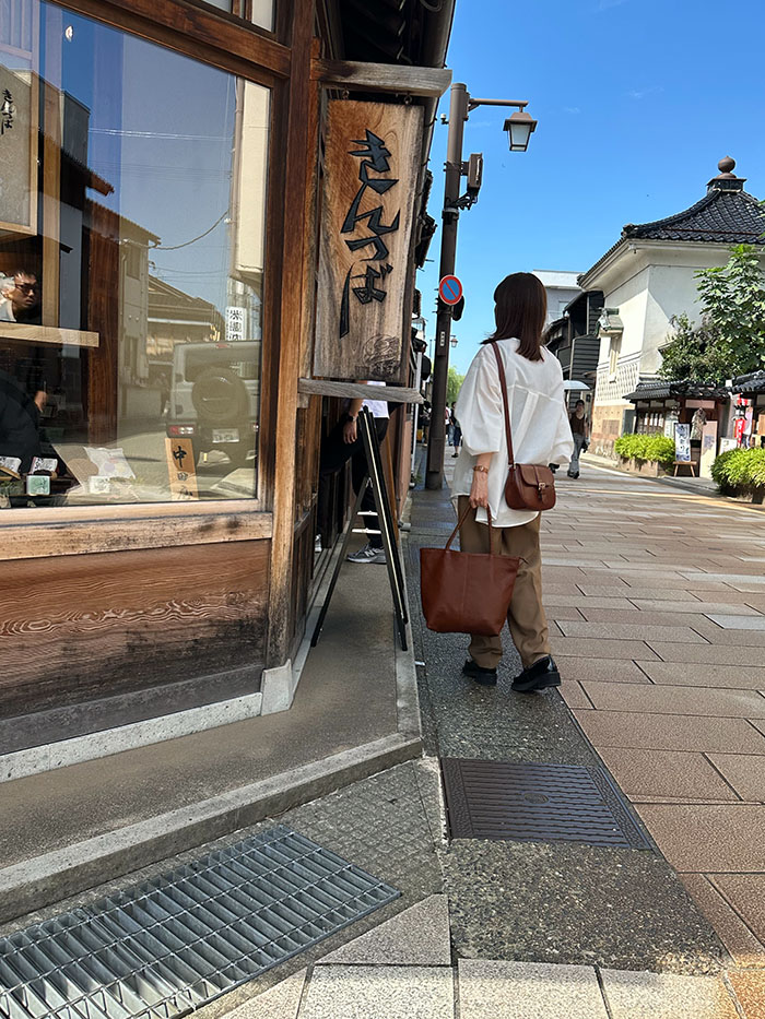 ひがし茶屋街を本革バッグと歩く50代女性