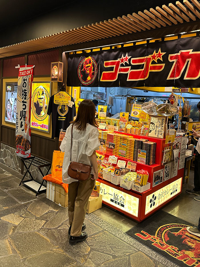 金沢旅行でゴーゴーカレーのお土産を選ぶ50代女性